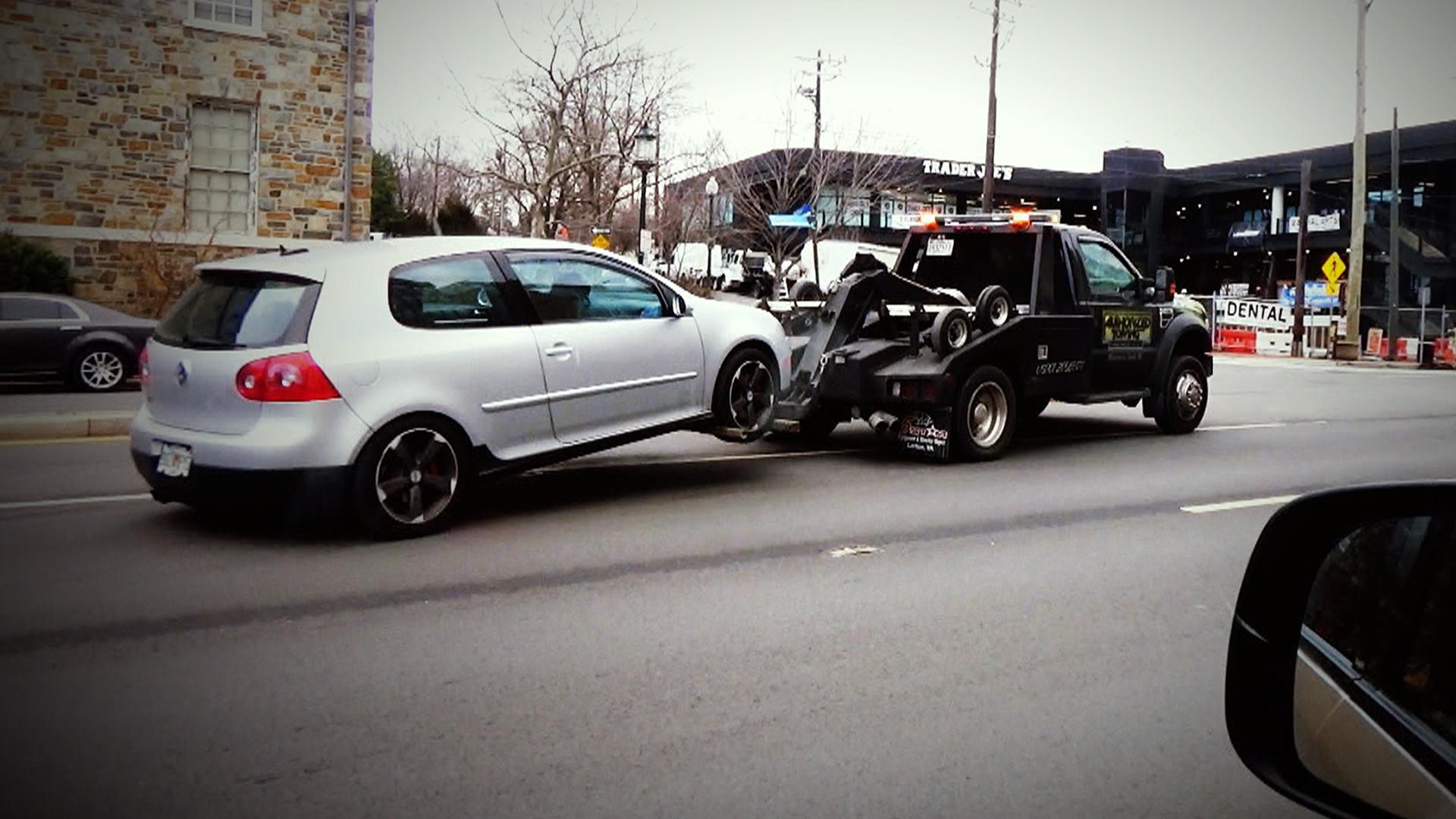 Truck towing white vehicle